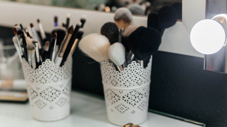 makeup brushes in white cups