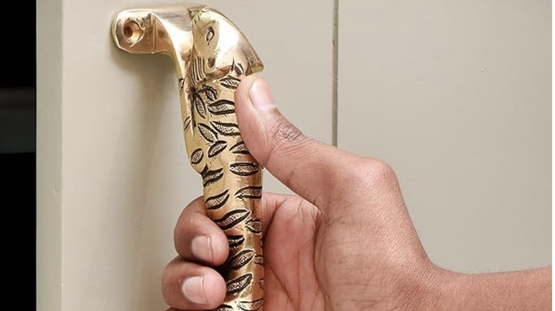 A brass door handle in the shape of a jaguar or tiger.