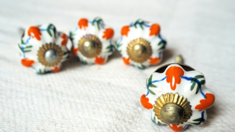 Ceramic, pumpkin-shaped knobs with painted details.