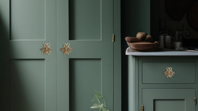 Bee-shaped door handles on a closet door and drawer.