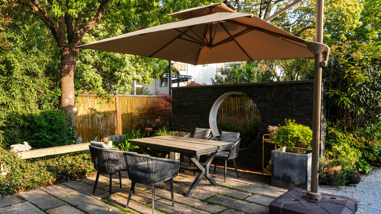 Outdoor wooden dining table and chairs with umbrella shade