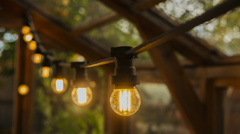 String lights hanging from exposed beams of an outdoor patio