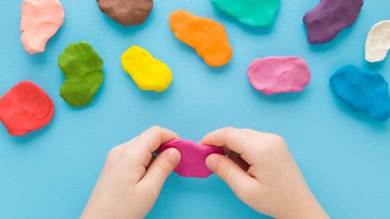 hands with different Play-Doh colors