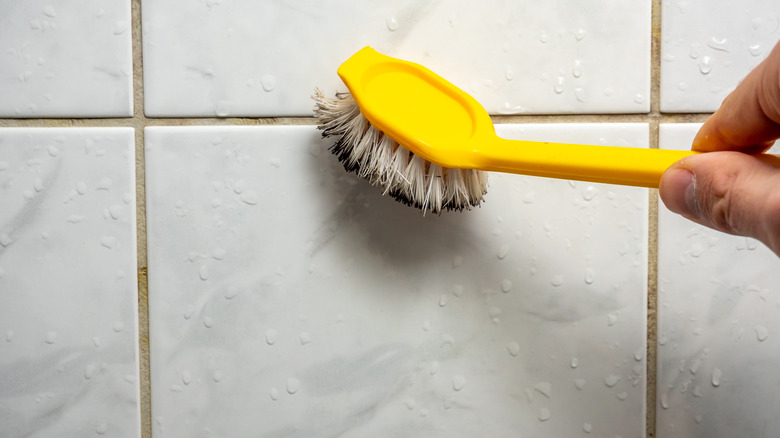 using brush to clean grout