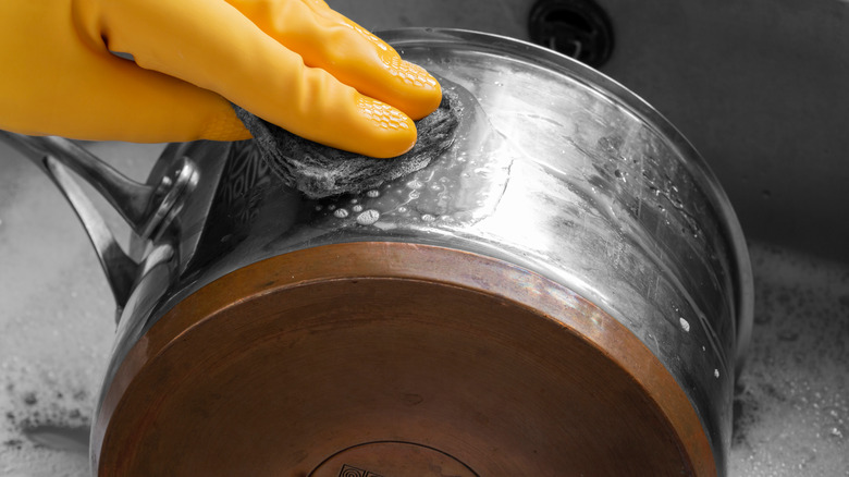 hand cleaning metal pot