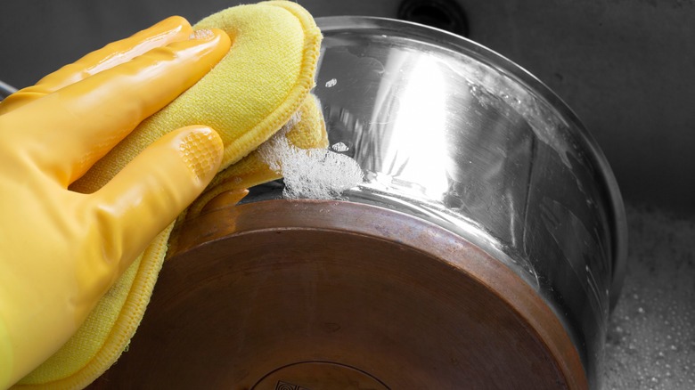 Person scrubbing stainless steel pot