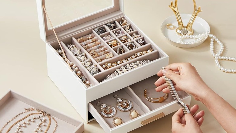 A person taking jewelry out of a jewelry box