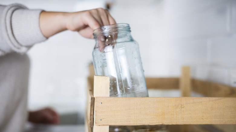 person holding empty glass jar