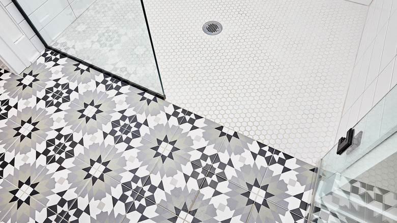 Gray floral tile in bathroom near white shower