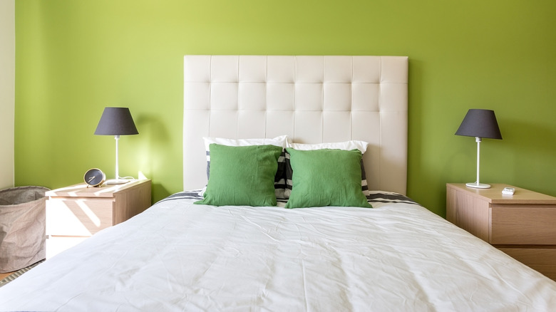 white bed and green wall