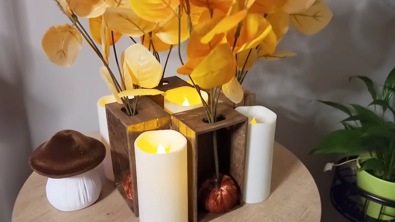 Decorative wooden centerpiece made with crates and LED candles with yellow flowers