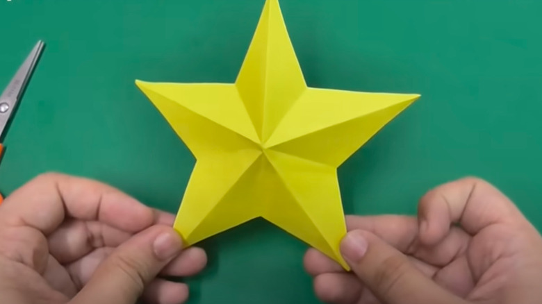 person holding paper star