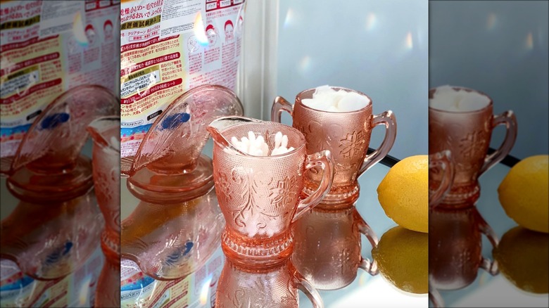 pink pitchers holding bathroom supplies