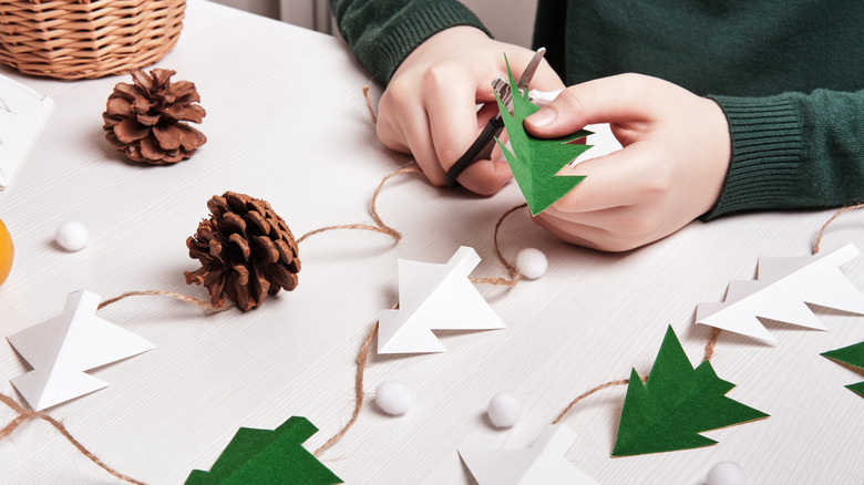 person cutting christmas tree garland