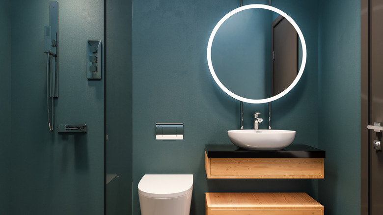 Teal bathroom with circle mirror