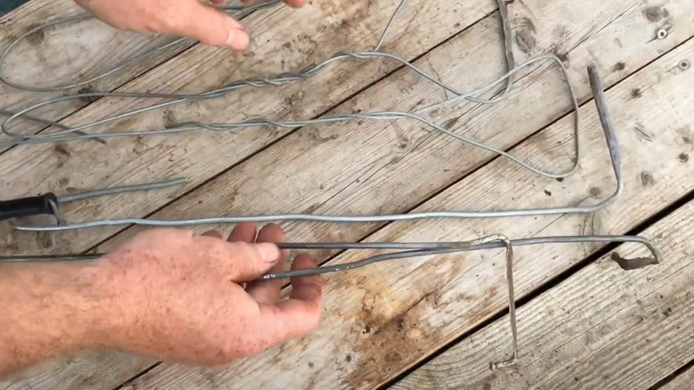 hands holding wire garden tool