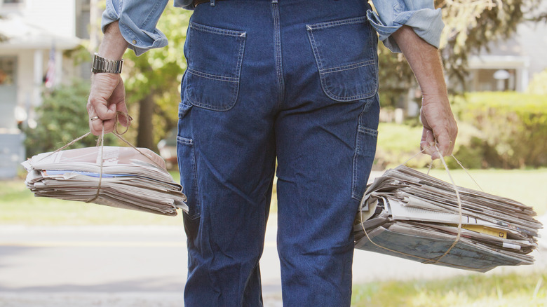 Man carrying bundles of newspapers