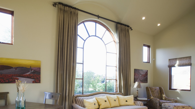 heavy drapes frame arched window