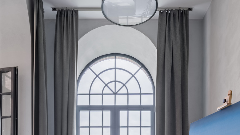 Long curtains flanking arched window