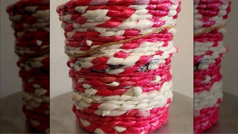 Tall red and white coiled basket made from plastic bags