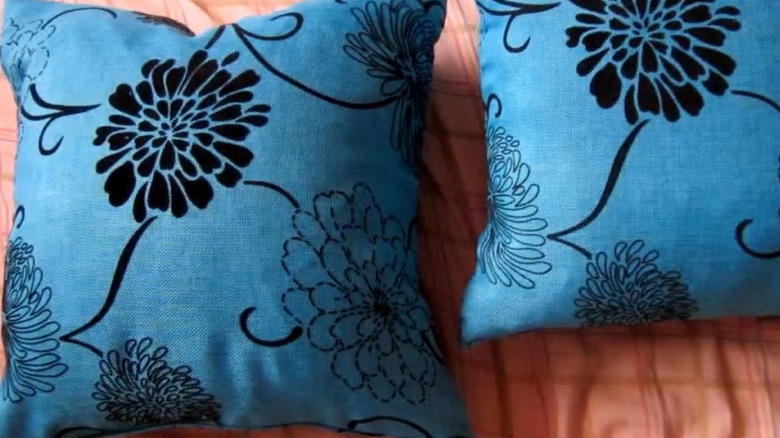 Plastic bag-filled blue throw cushions patterned with black flowers