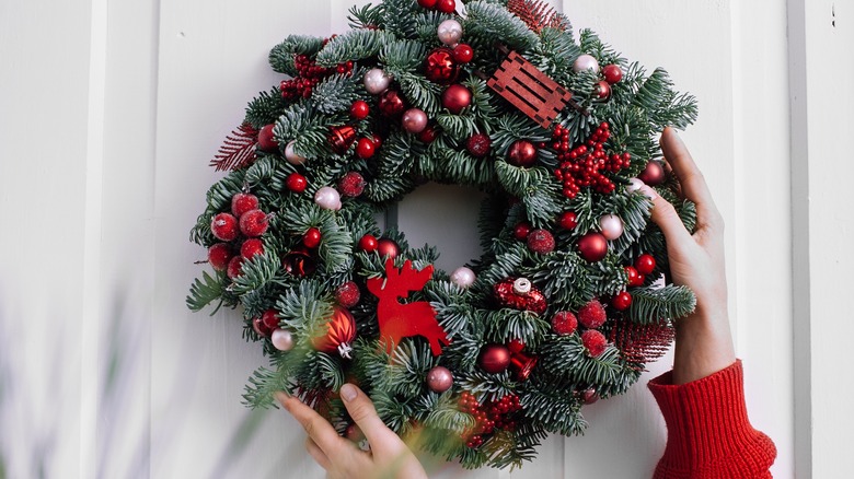 woman hanging a christmas wreath