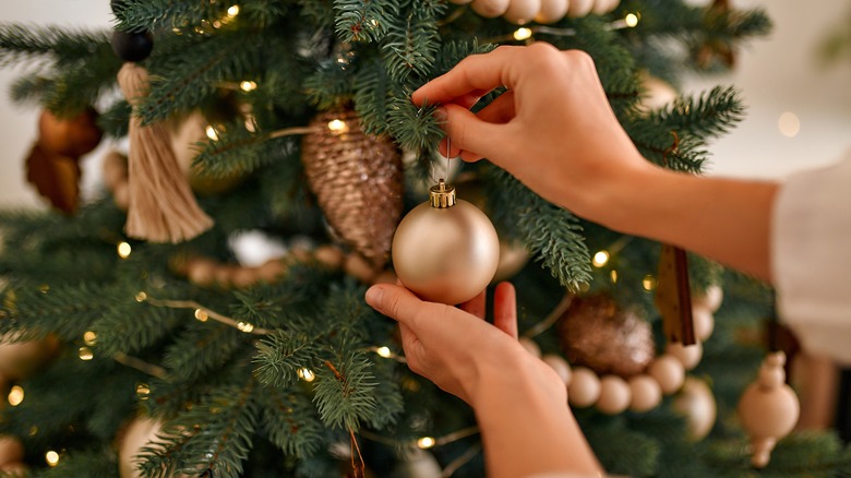 woman decorating a christmas tree