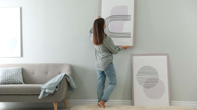 woman rearranging art