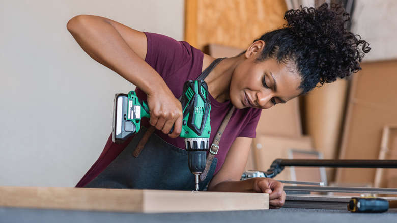 Woman drilling into wood