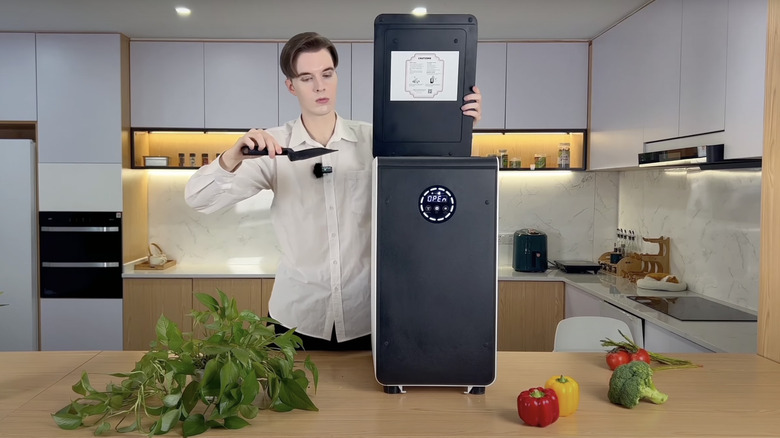 A person using the GEME composter in their kitchen