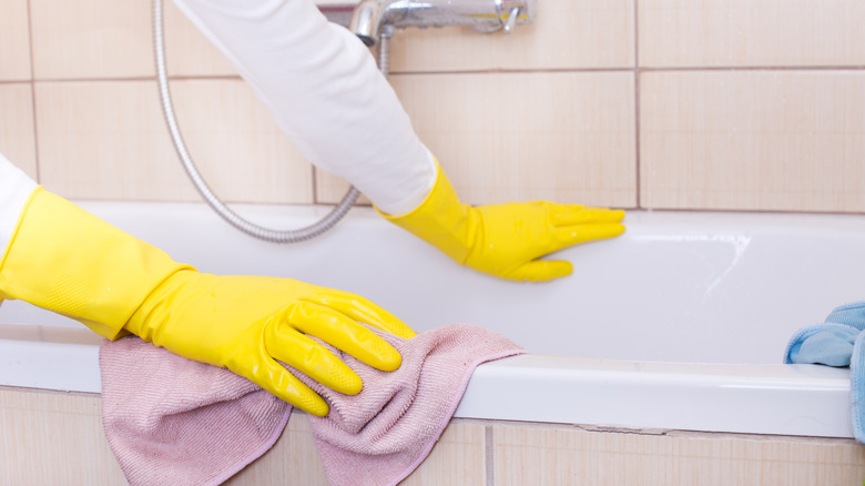 Person scrubbing side of tub