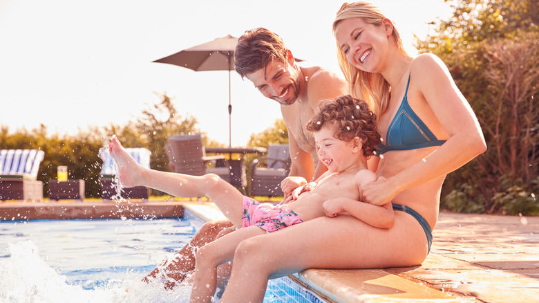 Family sitting on pool edge