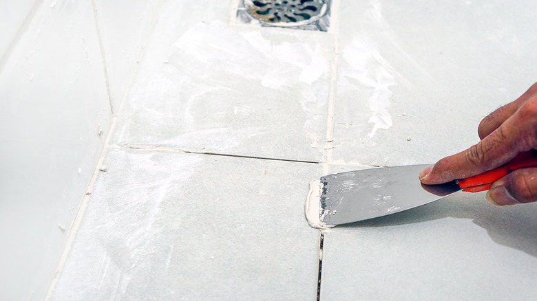 Hand applying grout to tile joints
