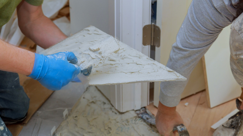 Person installing marble flooring corner piece