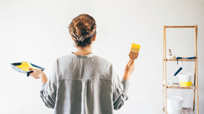 Woman about to paint wall