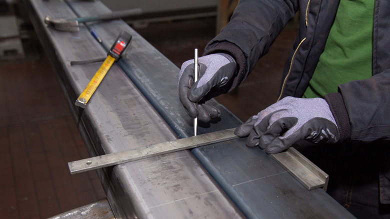 Hands marking metal piece