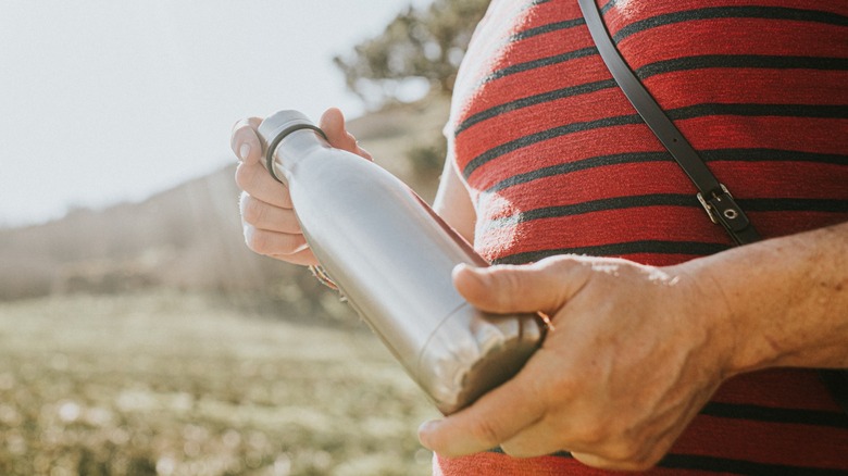 woman holding metal water bottle