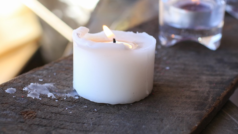 Candle burning on wood