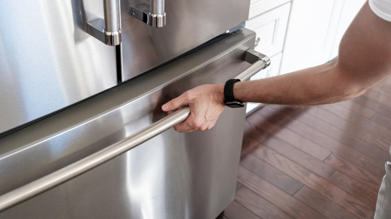 Hand on freezer door handle