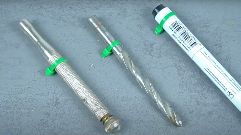 Zip ties wrapped around a pen and drill bits