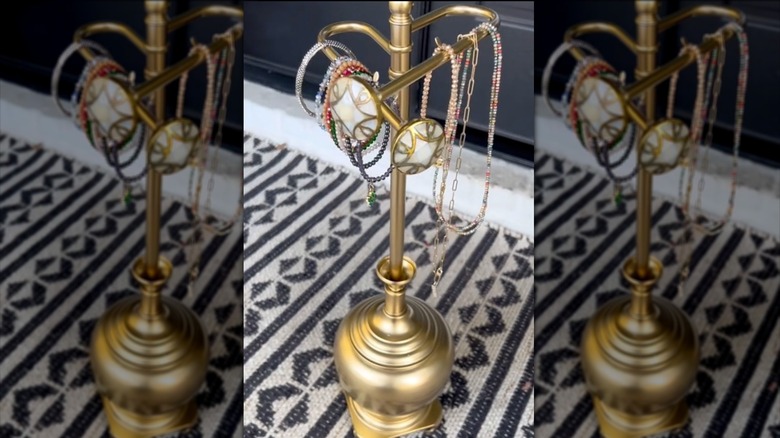 a gold jewelry holder made from an old lamp