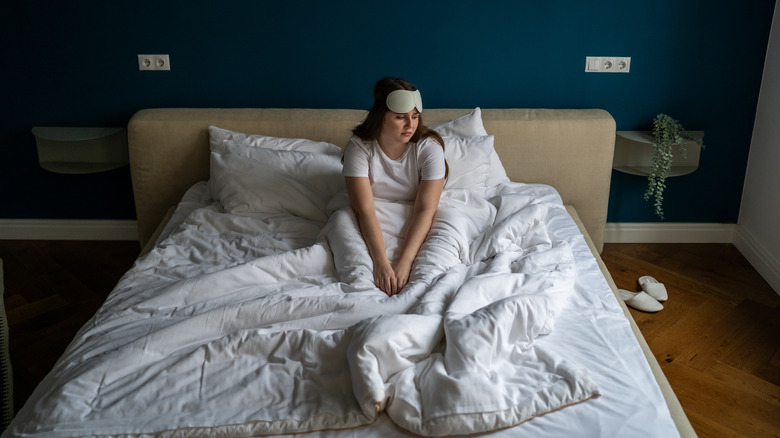 Person sitting unhappily on bed