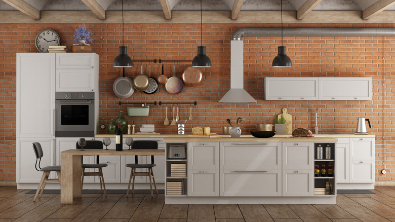 white kitchen with brick walls