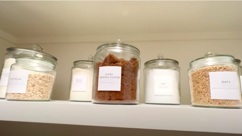 Labeled glass jars in pantry