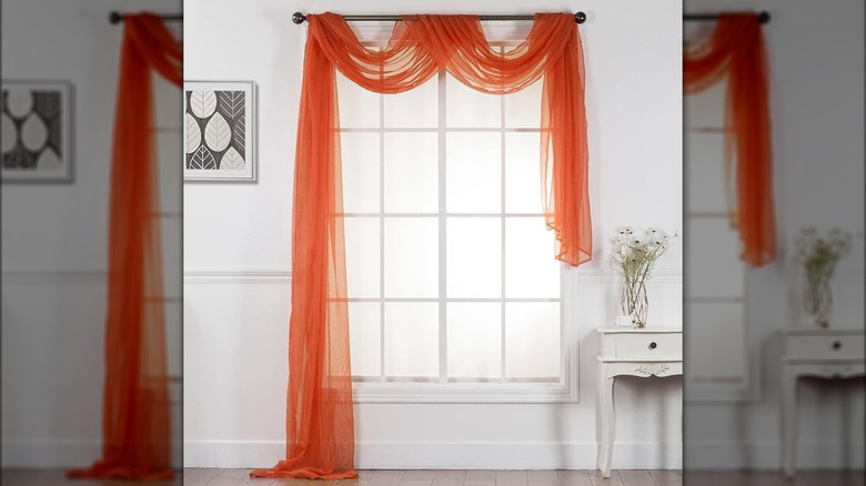 window with orange curtain scarf