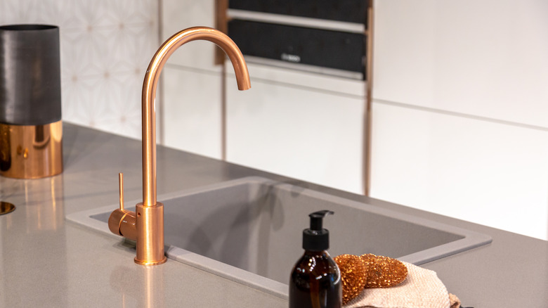 copper faucet with gray sink