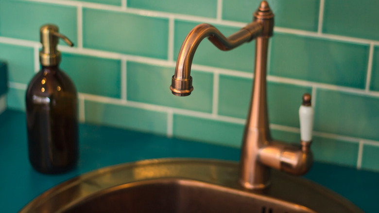 copper sink with green backsplash