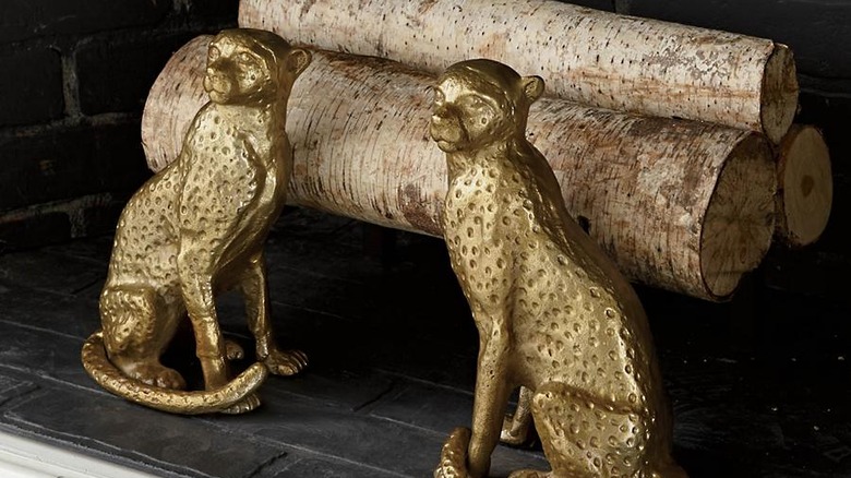 gold cheetah andirons in fireplace