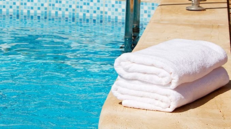 stack of towels beside pool