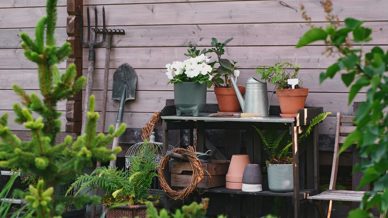 Pots and gardening accessories sit on an outdoor workstation